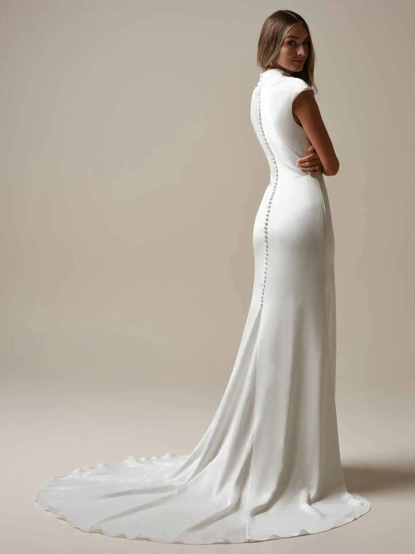 Model is wearing a sheath bridal gown with a cowl neckline by rebecca ingram