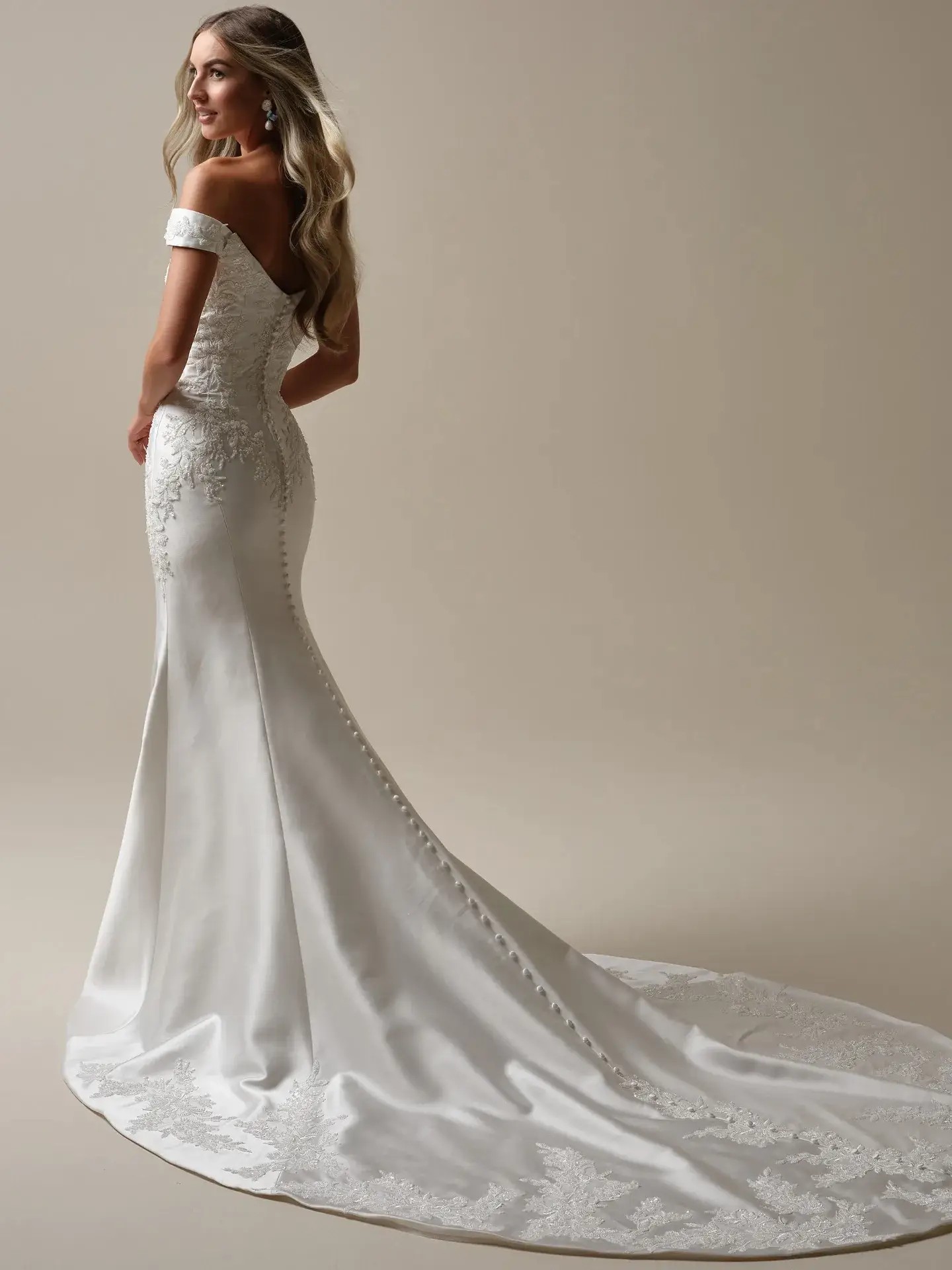 Model is wearing an off the shoulder fit and flare wedding dress by maggie sottero