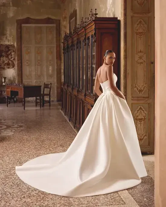 model is wearing a strapless ball gown bridal dress