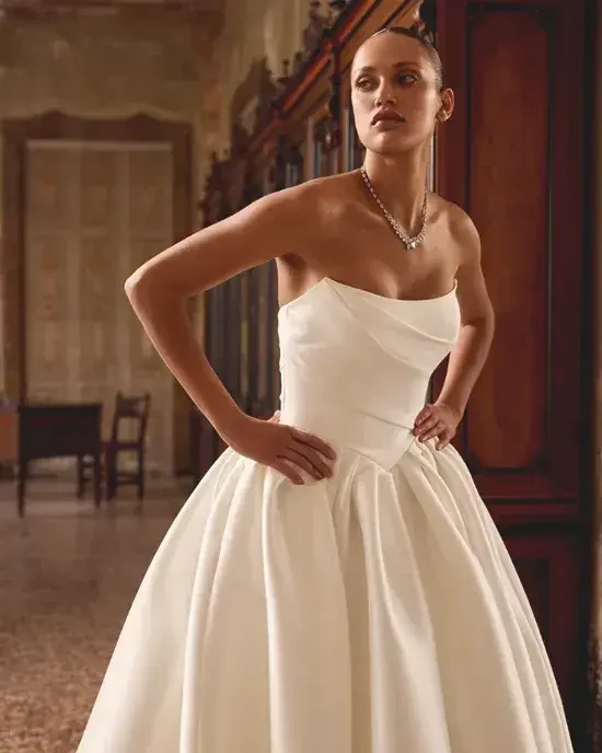 model is wearing a strapless ball gown bridal dress