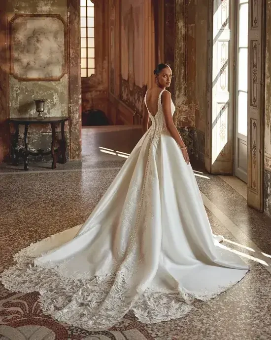 model is wearing a sleeveless ball gown wedding dress