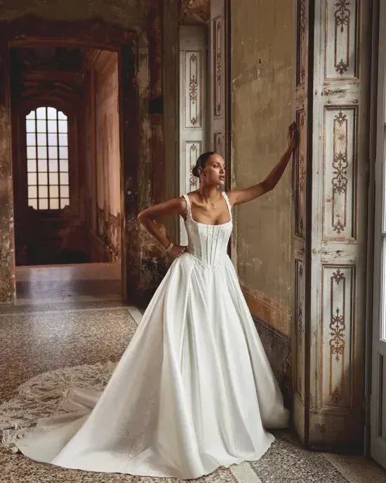 model is wearing a sleeveless ball gown wedding dress