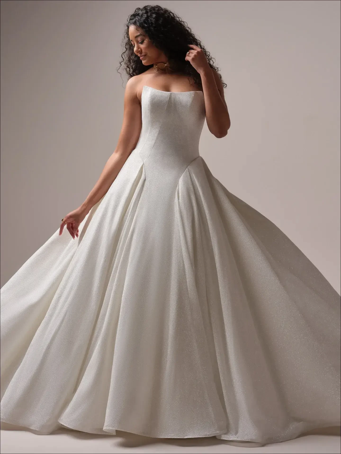 model is wearing a strapless basque waist ball gown wedding dress