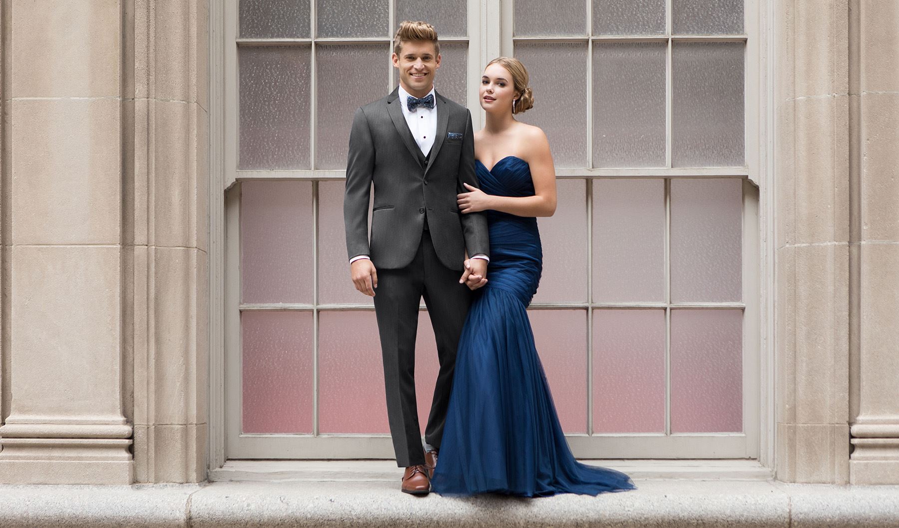 Сouple wearing a blue gown and a  dark-gray suit